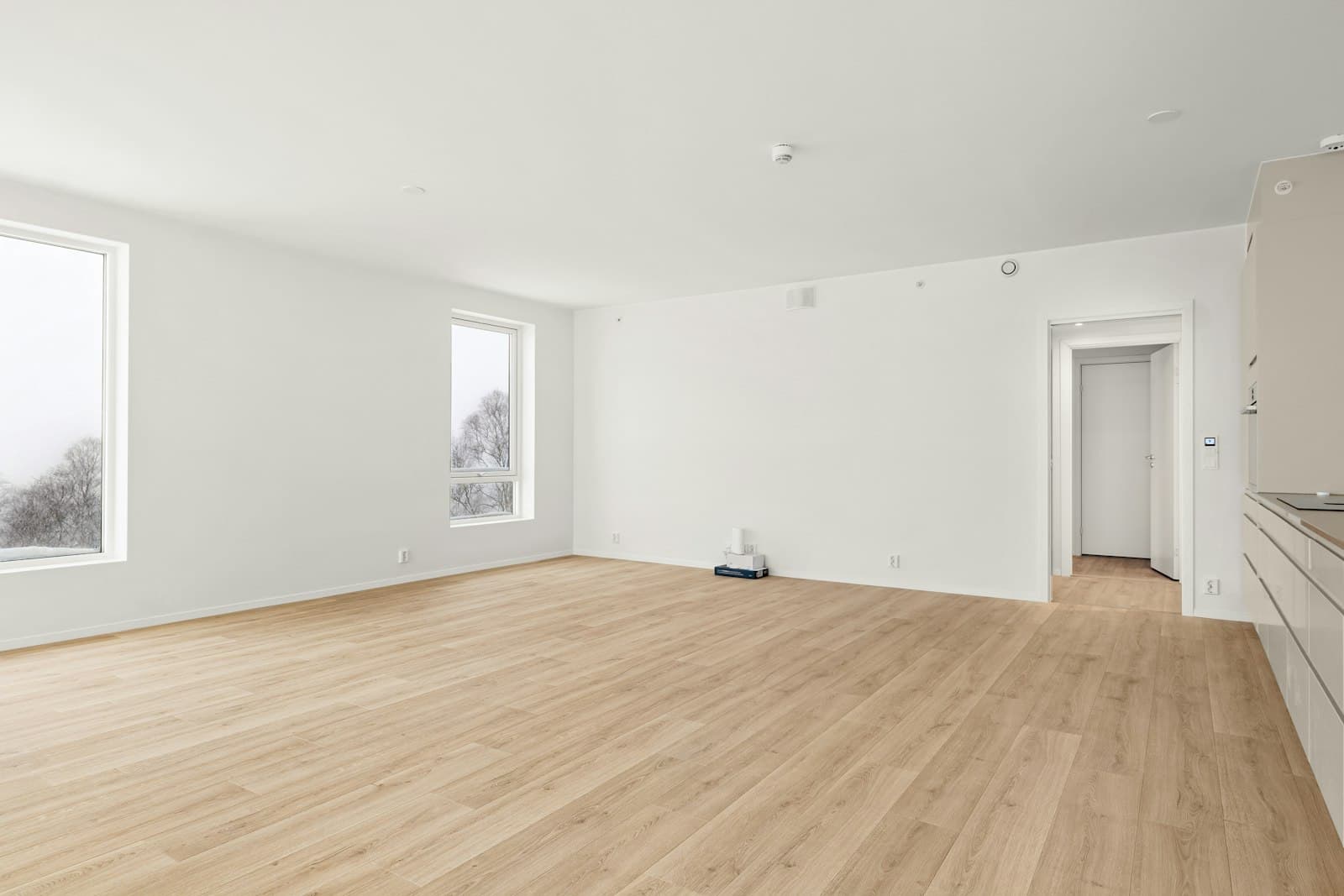 Interior de vivienda con ventanales y suelo de madera